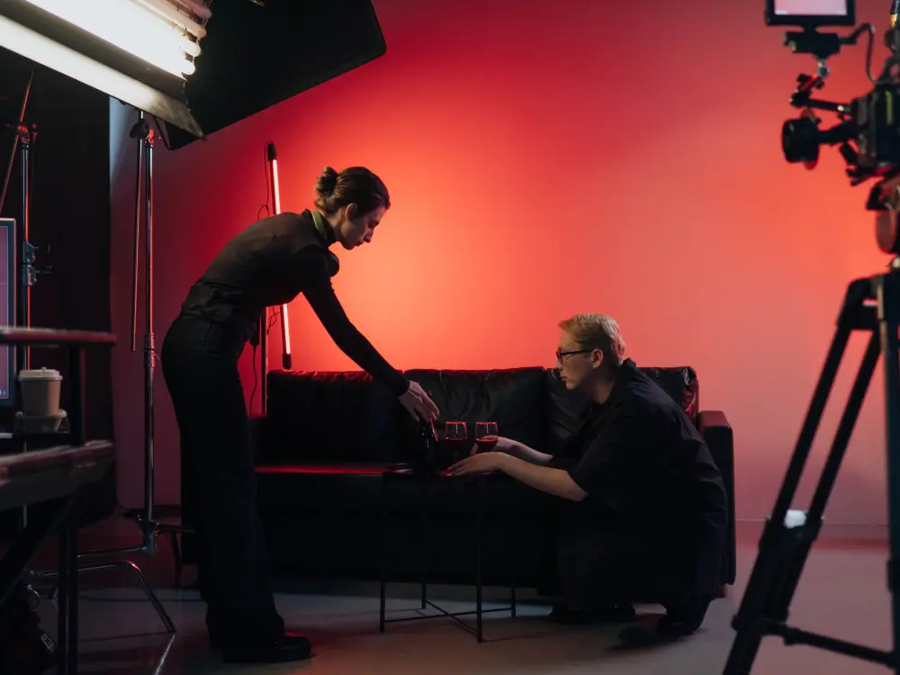 Film crew rigging lights and dressing a studio set