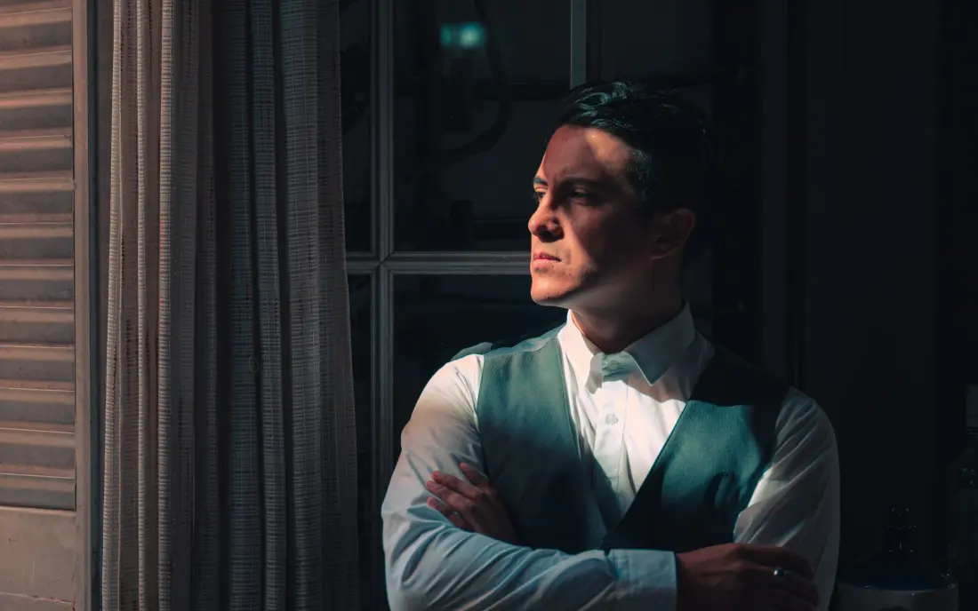 Still from Ember Season: a man in period dress standing at a window