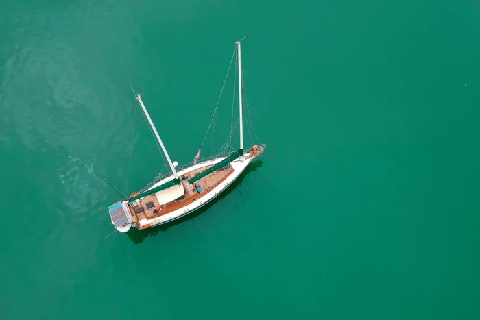 Aerial view of a white sailing boat on turquoise water