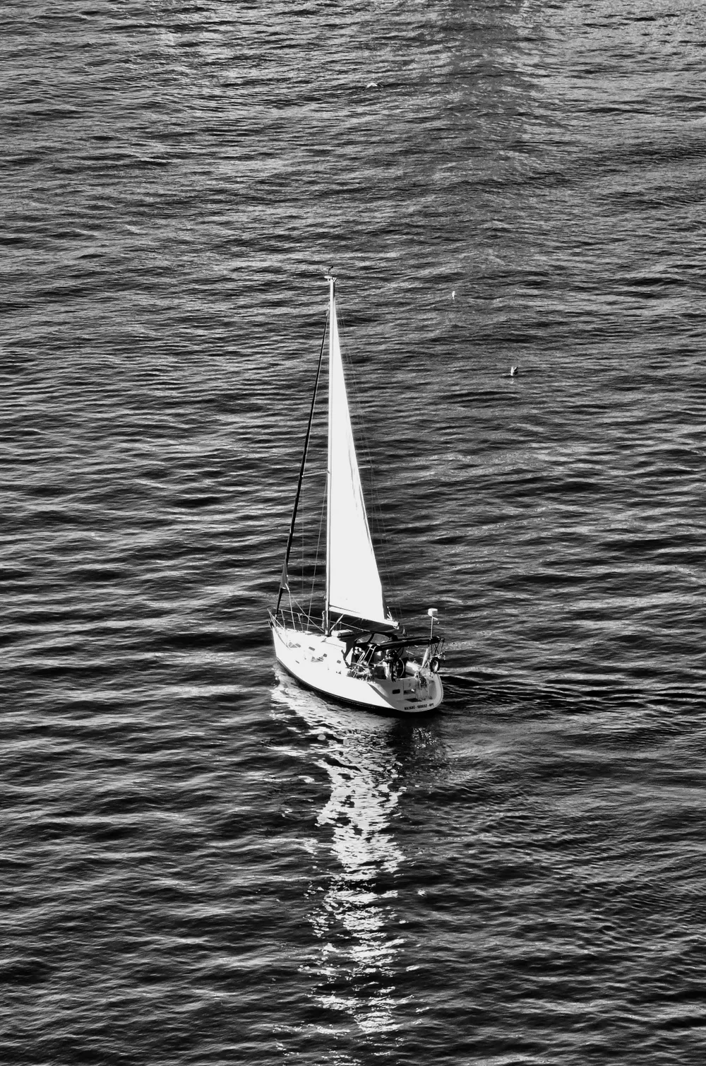A sailing boat crossing rippled open water