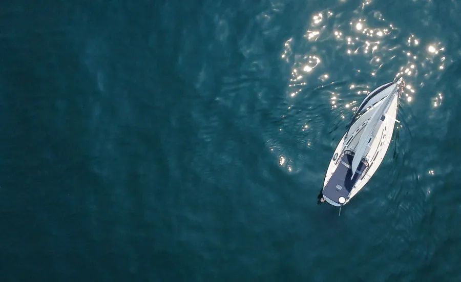 Aerial view of a sailing boat on wide clear water
